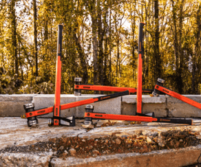 HEADLOCK family of sledgehammers, axes, & mauls on a concrete slab & cinder block wall with trees in the background