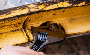 Man using a Crescent wide jaw adjustable wrench to loosen a fastener