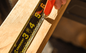 Framer using a Crescent NITE EYE tape measure and carpenter pencil to measure and mark lumber