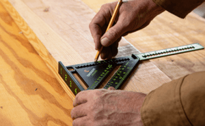 Man using a Crescent NITE EYE extendable rafters square to measure lumber