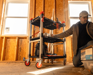 Male general contractor using Crescent SITERUNNER folding cart in a residential construction environment