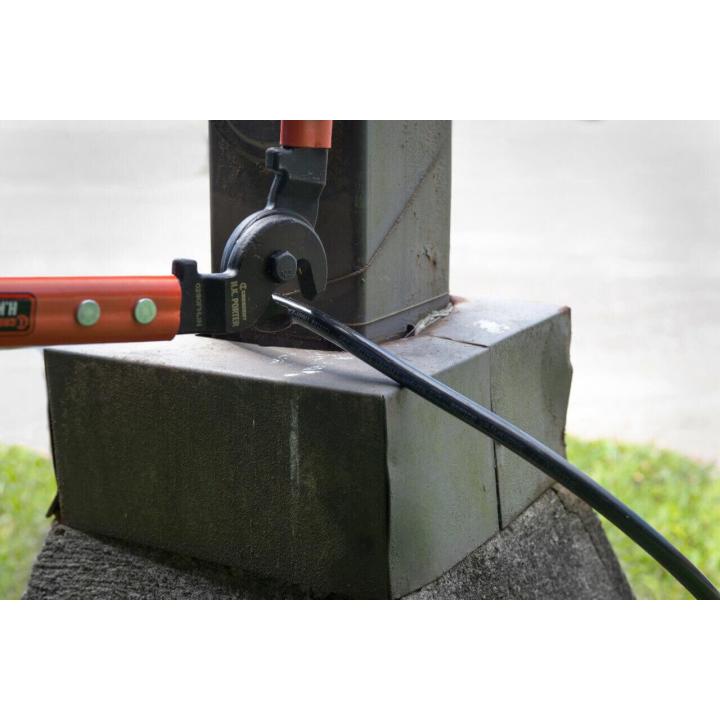 Crescent H.K. Porter cable cutter positioned around a black utility cable near a metal support structure during a cable-cutting application.