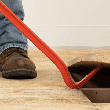 Man using a Crescent pry bar to lift subflooring